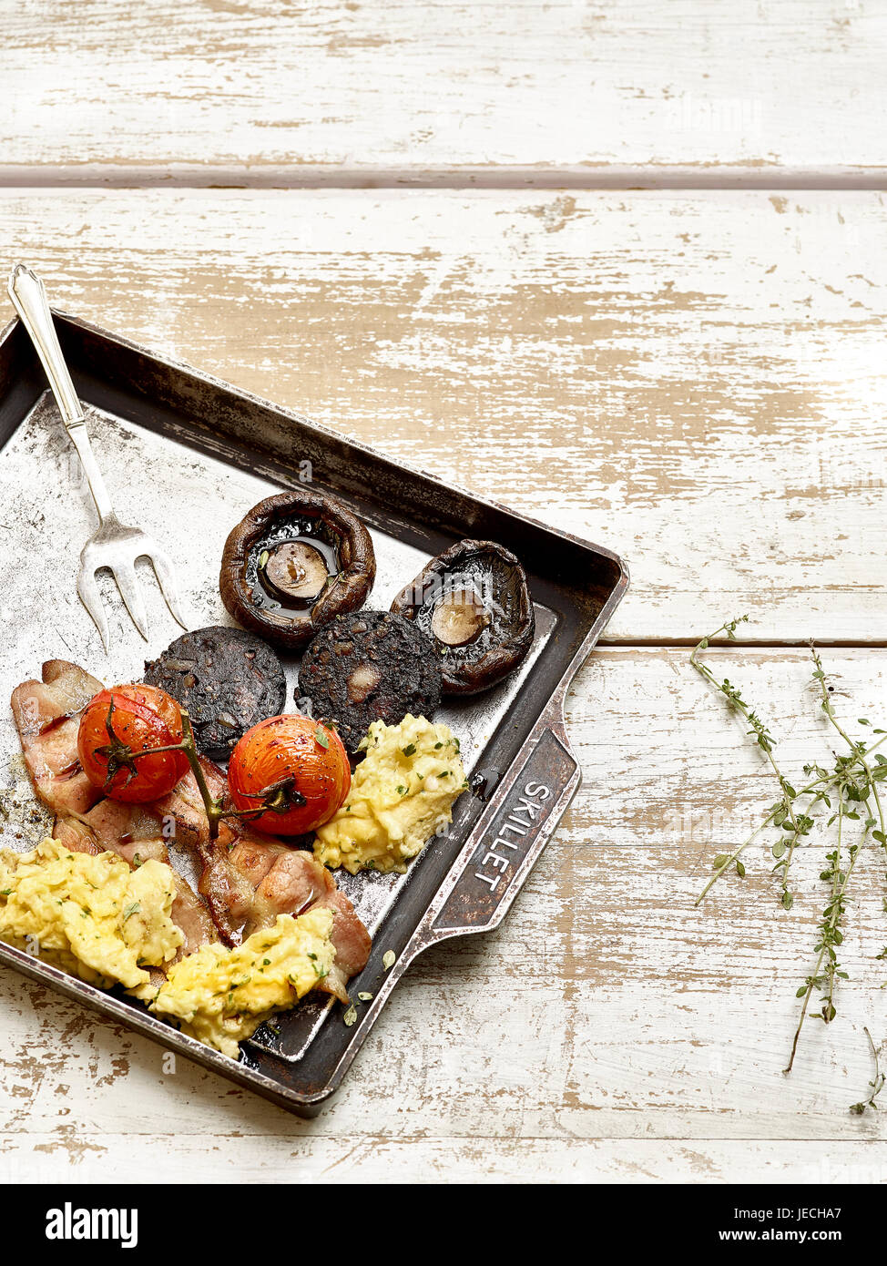 Un petit-déjeuner anglais complet avec du boudin noir bacon champignons et oeufs Banque D'Images