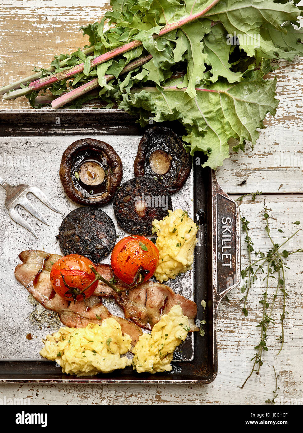 Un petit-déjeuner anglais complet avec du boudin noir bacon champignons et oeufs Banque D'Images