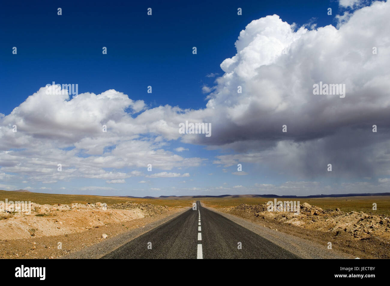 Le Maroc, Ouarzazate, route de campagne, ciel nuageux, Afrique, Afrique du Nord, paysage, de largeur, de distance, d'horizon, point de fuite, point de fuite, perspective, perspective centrale, Ciel, nuages, la solitude, à l'extérieur, déserte, Banque D'Images