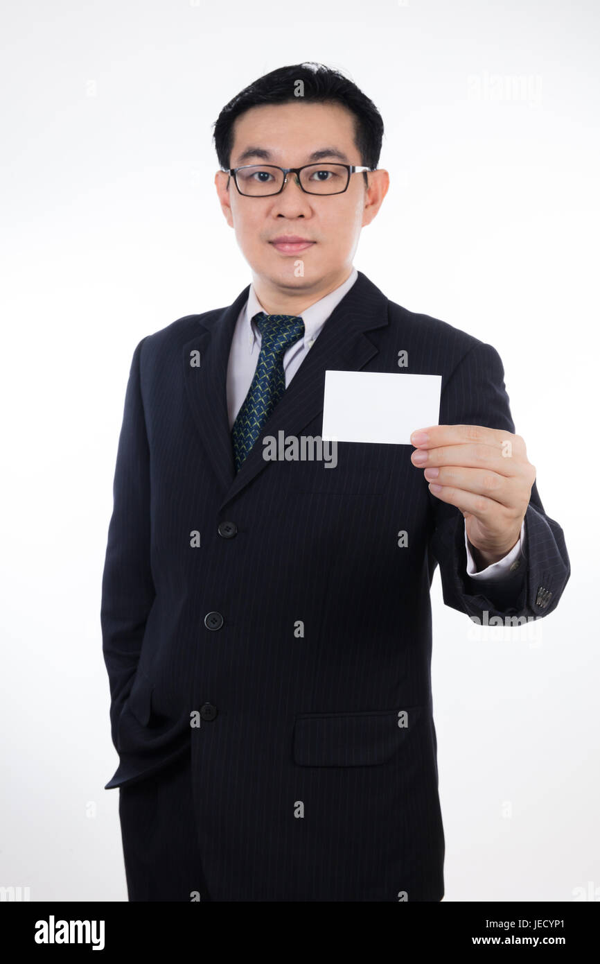 Chinois asiatique Smart homme portant costume et holding blank card en isolé sur fond blanc. Banque D'Images