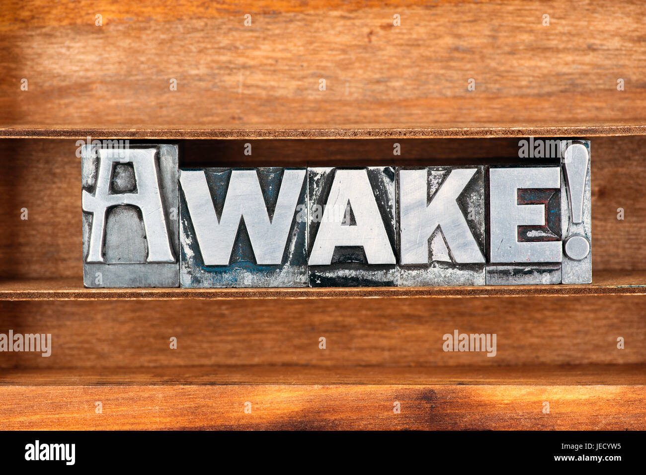 Awake mot mot d'exclamation faite de type typographique métallique sur plateau en bois Banque D'Images