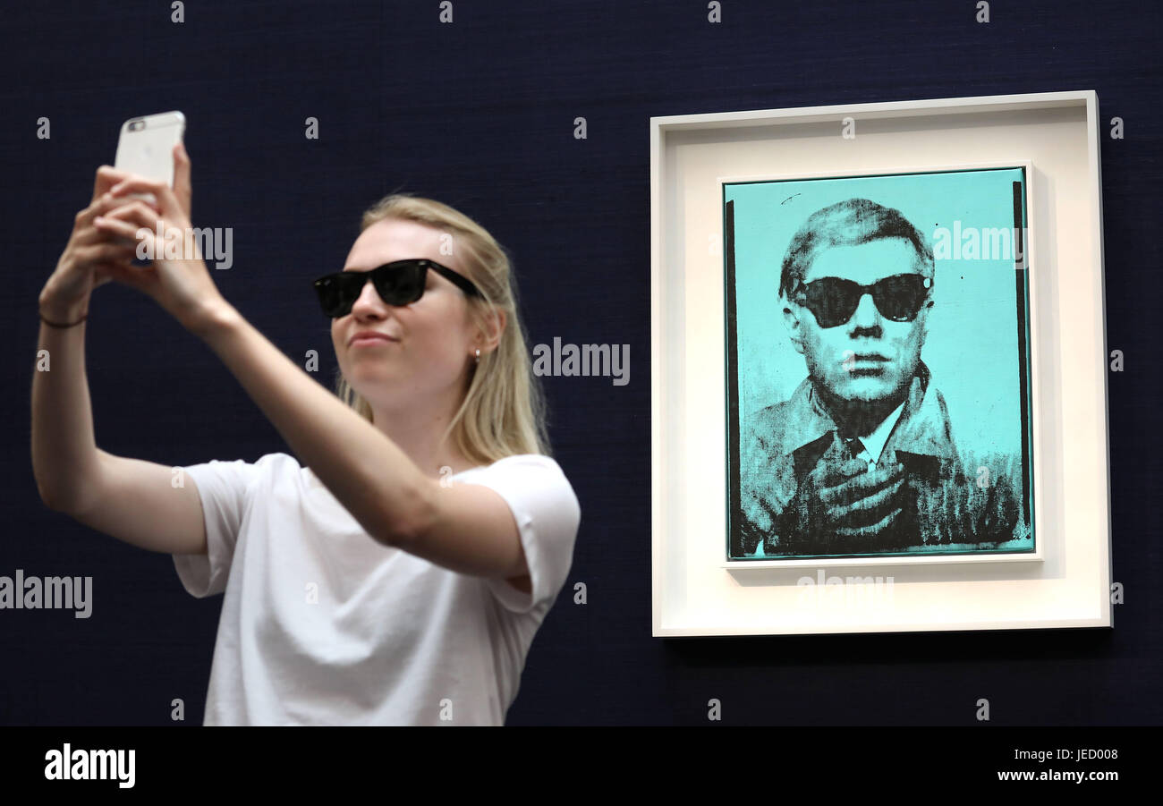 Un visiteur prend une avec selfies "Portrait" par Andy Warhol (estimation : &pound;5 millions - &pound;7 millions) l'une des oeuvres en vente à la Sotheby's Art Contemporain Vente du soir le 28 juin à Londres. Banque D'Images