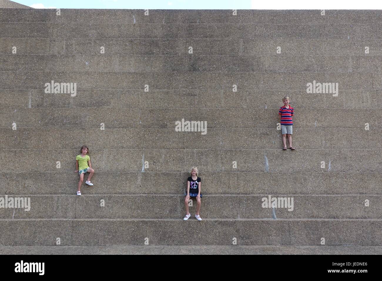 Trois enfants sur la montagne urbaine à Fort Worth Water Gardens Banque D'Images