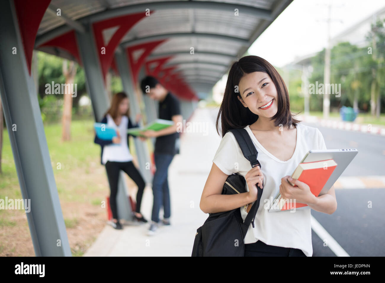 Étudiant à l'université de l'Asie en marche à pied et transporter ordinateur portable et sac à main. Banque D'Images