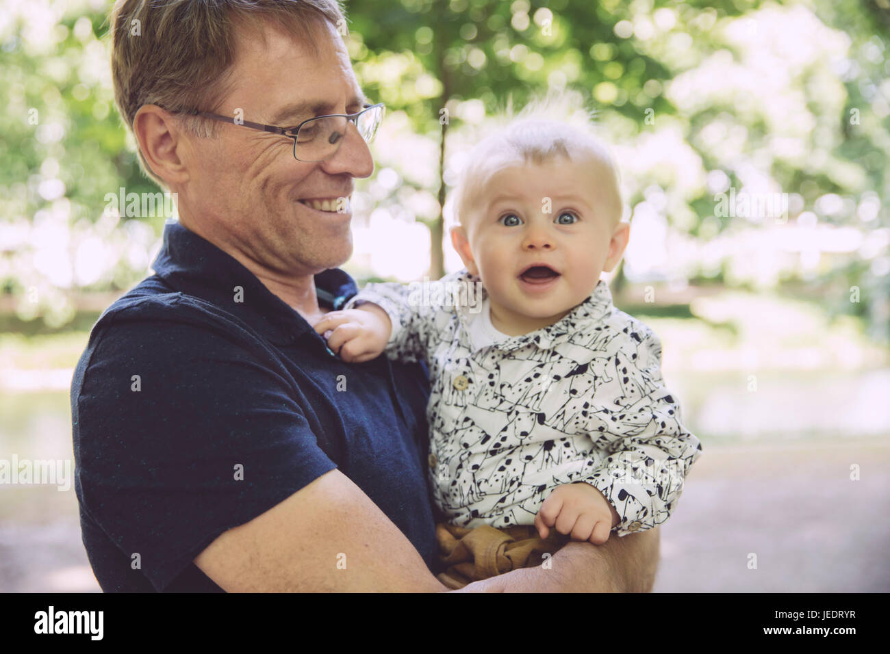 Smiling father holding surpris baby boy outdoors Banque D'Images