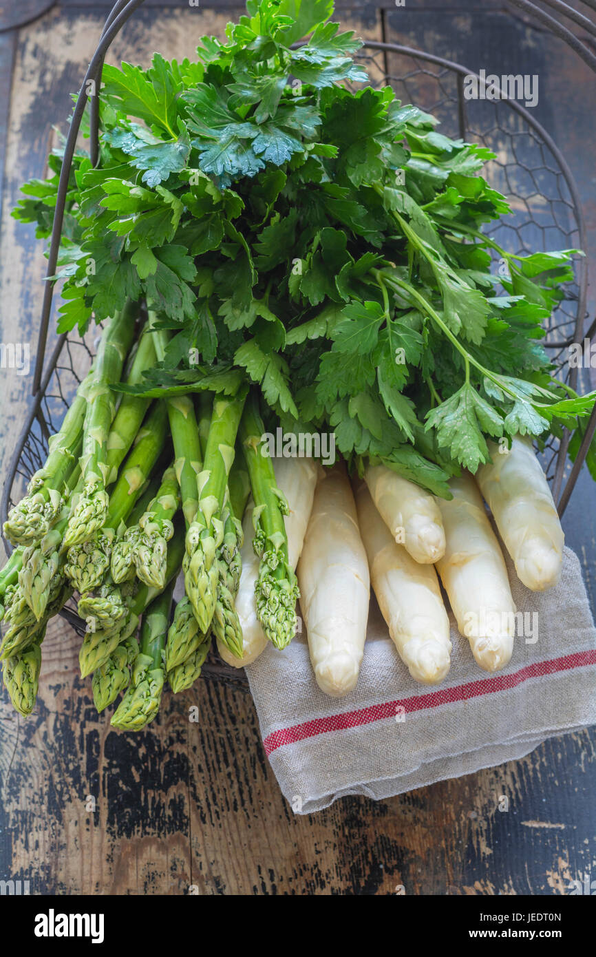 Panier avec asperges vertes et blanches, de persil plat et essuie-tout Banque D'Images