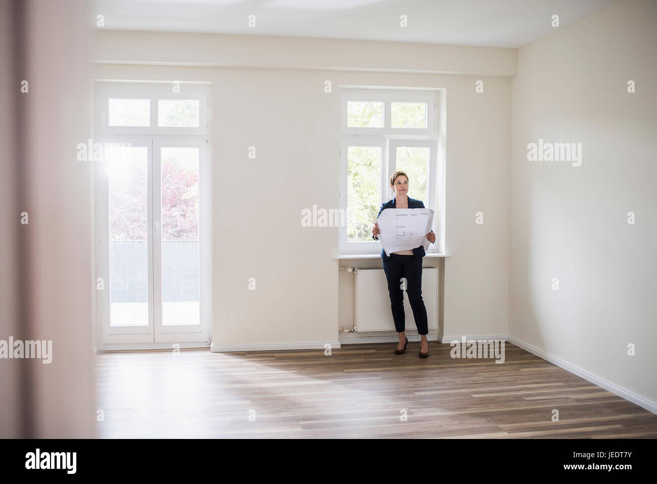 Femme en appartement vide avec plan Banque D'Images
