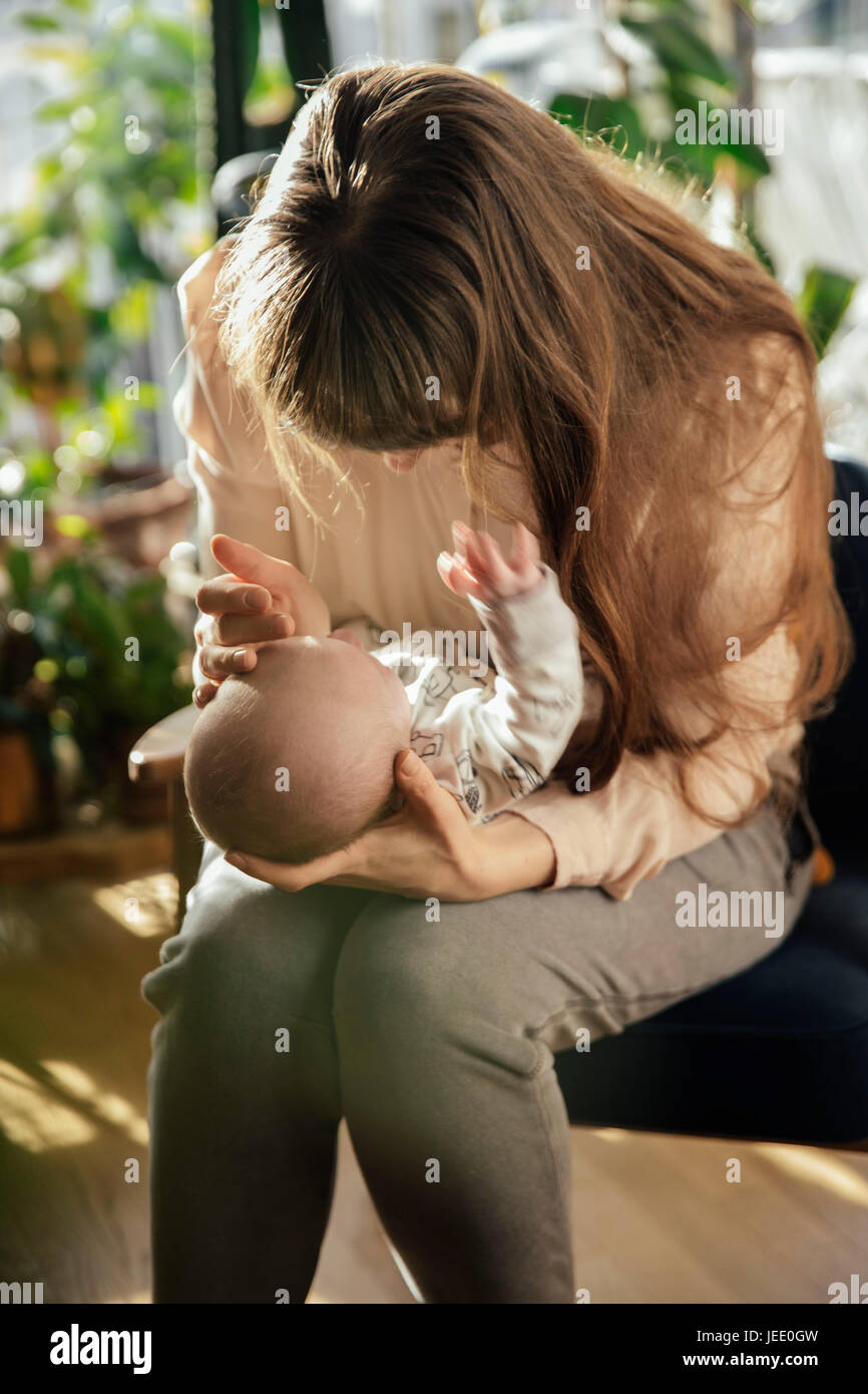 Caressant sa mère nouveau-né garçon à la maison Banque D'Images