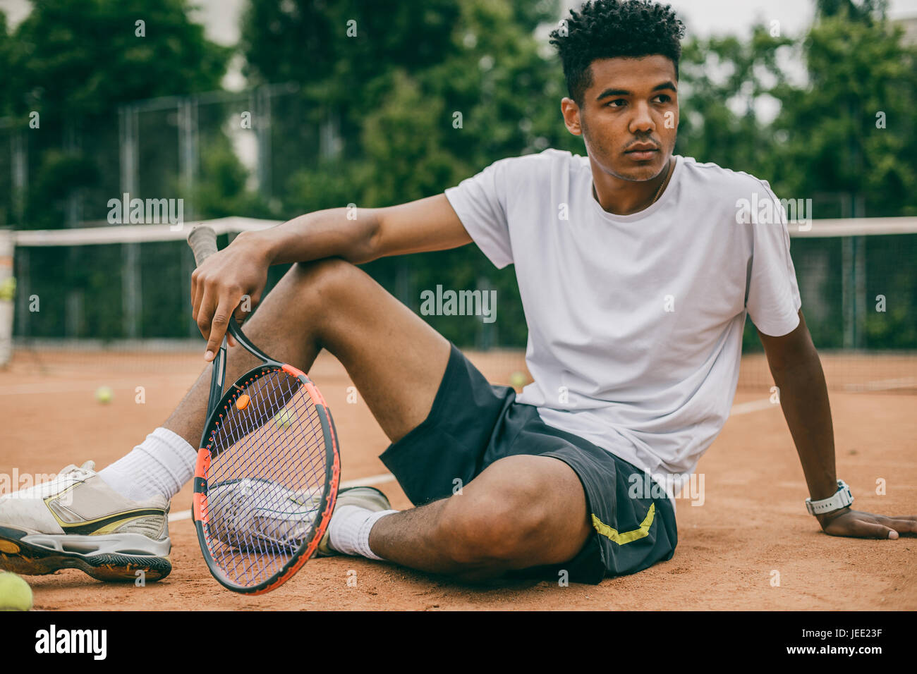 Homme africain et courte pause pendant le jeu de tennis Banque D'Images