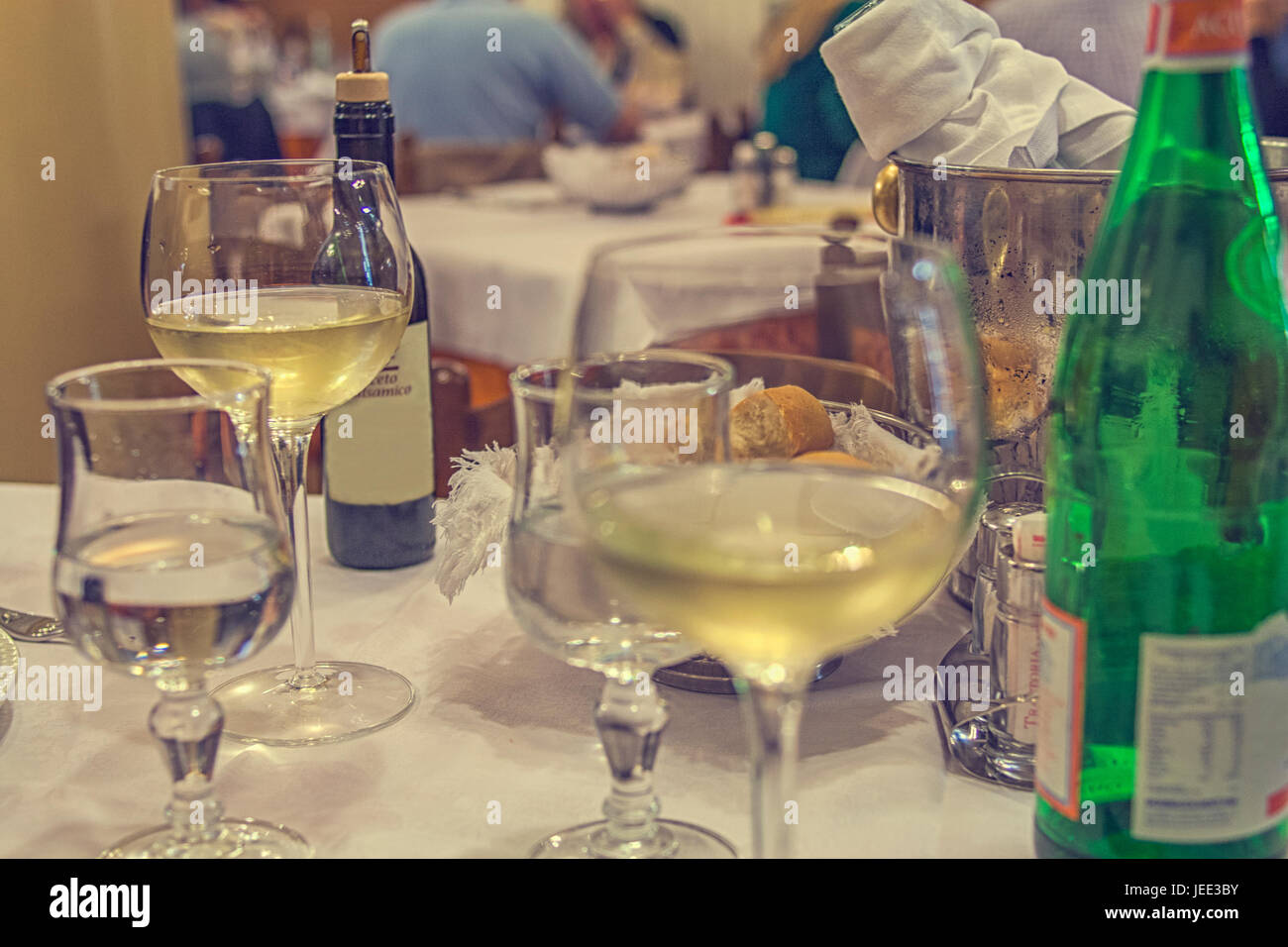 Réglage de la table après un dîner dans un restaurant italien avec du vin, bouteille, eau, et du pain Banque D'Images