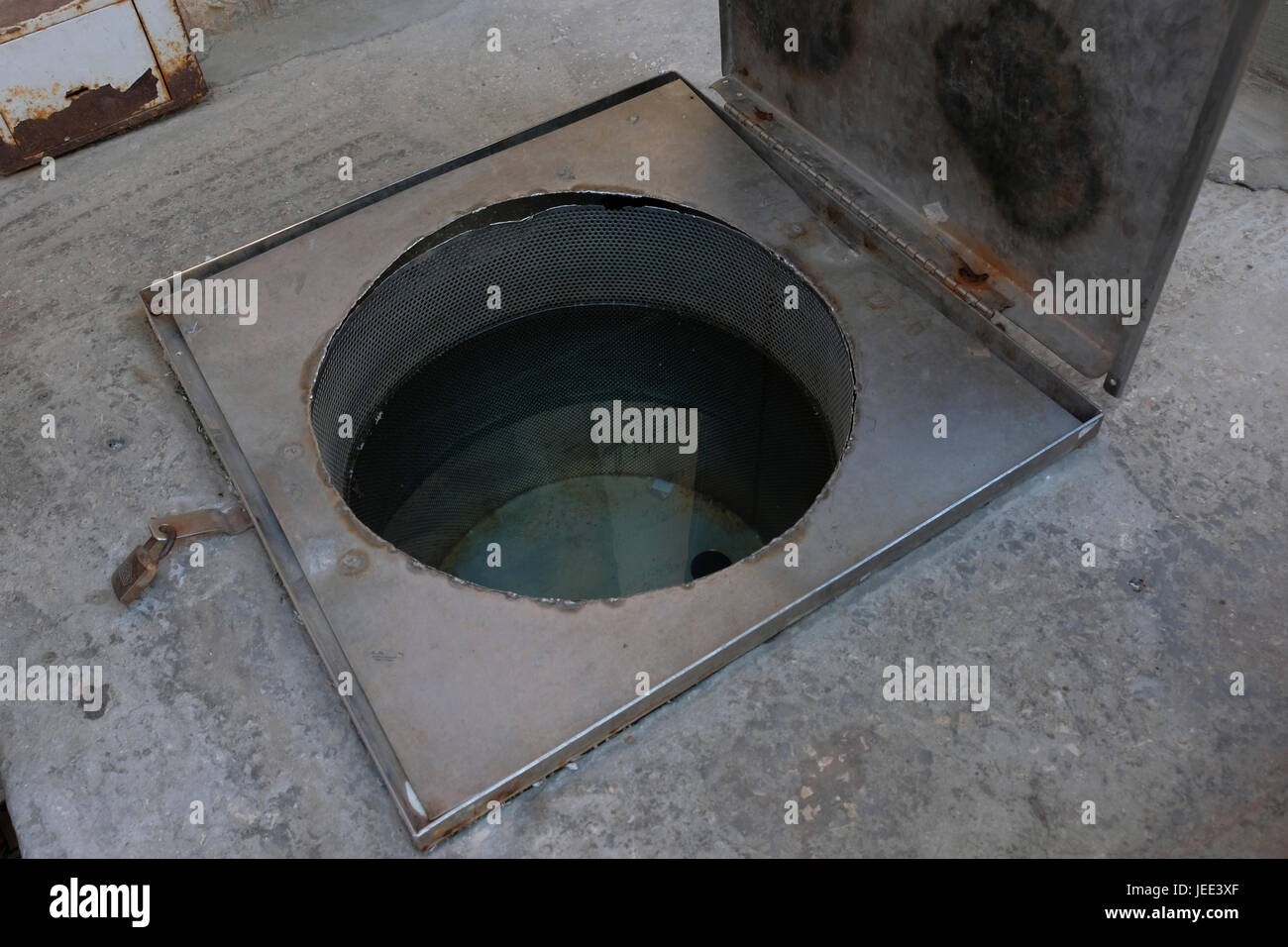 Un trou dans le sol rempli d'eau pour la Tevilat Kelim, dans lequel les juifs orthodoxes utilisent pour immerger d'ustensiles métalliques qui sont achetés ou acquis d'un non-Juif avant leur première utilisation. Situé dans le quartier des maisons Rand Batei hassidique fondé en 1908 à Nachlaot ou Nahlaot un regroupement de 23 quartiers ancienne cour qui peuplaient la nouvelle ville après avoir quitté la ville fortifiée de Jérusalem à la fin du 19e siècle situé dans l'ouest de Jérusalem Israël Banque D'Images