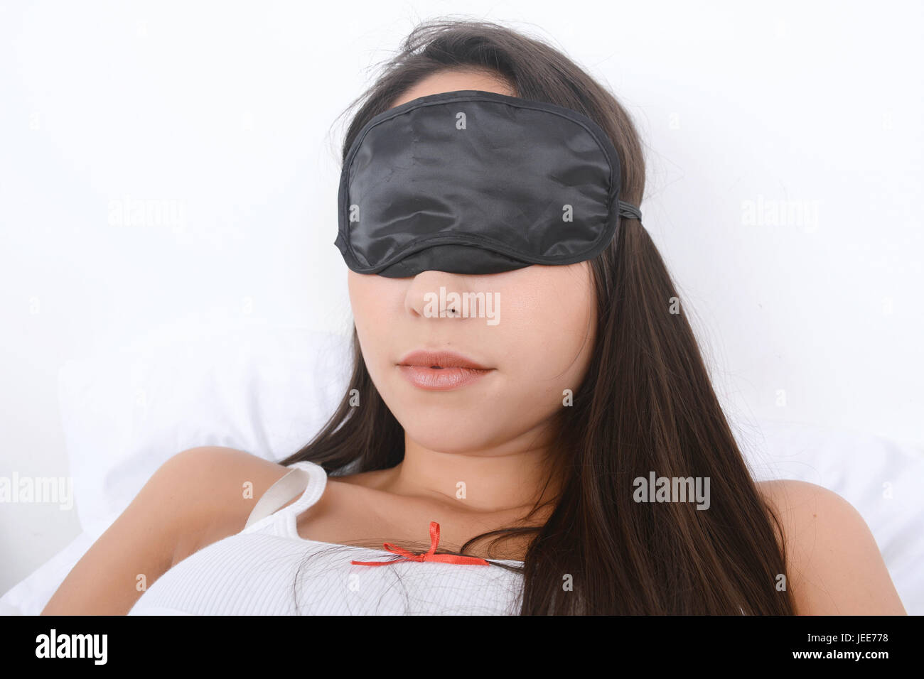 Close-up of beautiful young woman sleeping in bed avec un masque pour les yeux. À l'intérieur. Banque D'Images