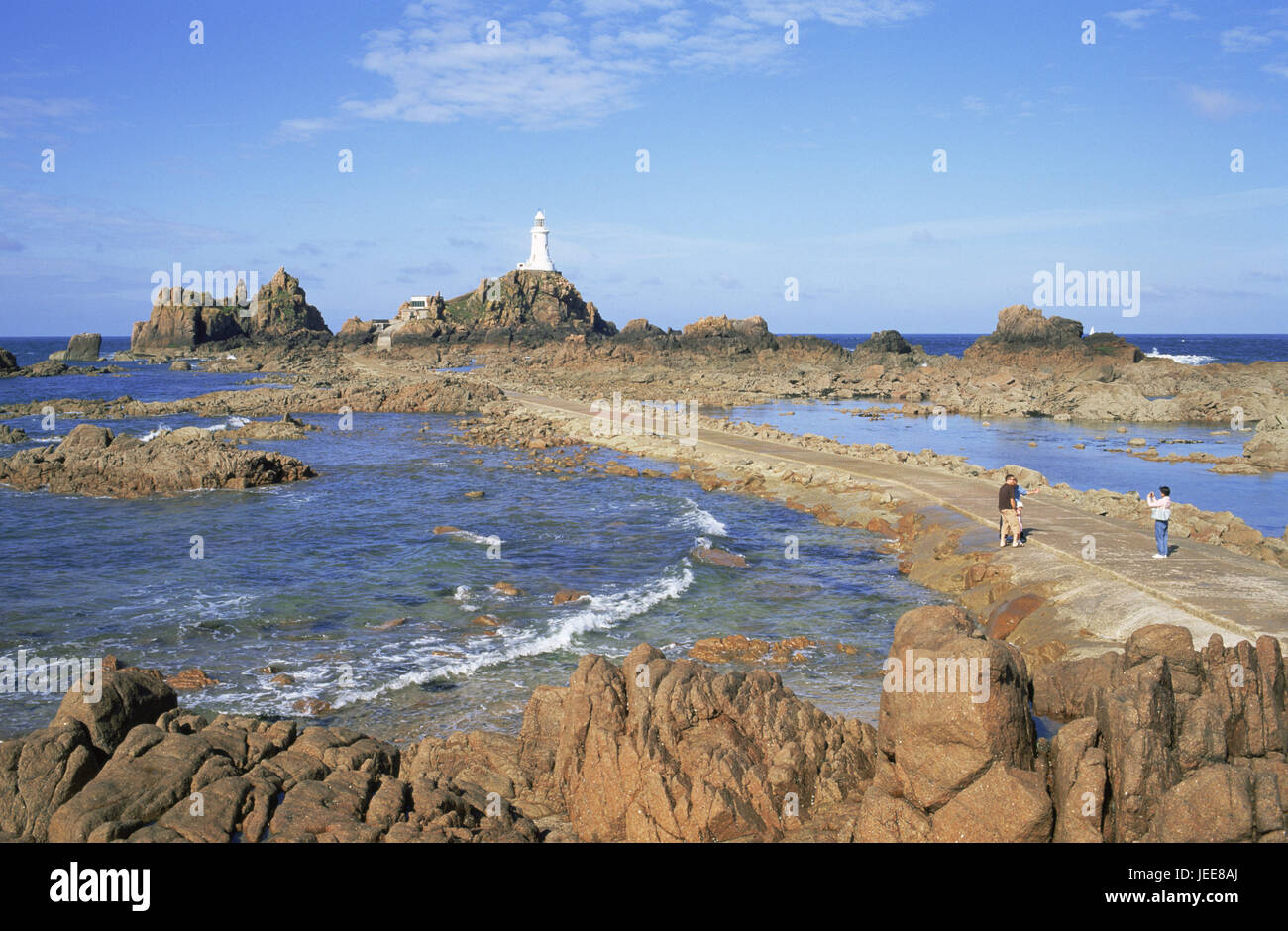 En Grande-Bretagne, les Channel Islands, Île de Jersey, la Corbiere, Lighthouse, touristiques, de l'Europe, côte, rock, Rocky, bâtiment, architecture, tour, Beacon, caractère de la mer, de l'orientation, orientation, navigation, aide à la navigation, la navigation, ensoleillée, à l'extérieur, mer, ciel, nuages, bay, marée basse, personne, à pied, point d'intérêt, Banque D'Images