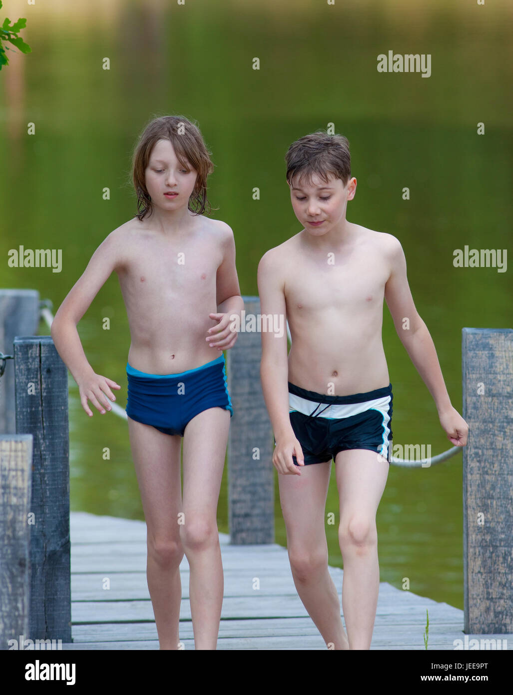 Deux garçons Walking on Jetty en été Banque D'Images