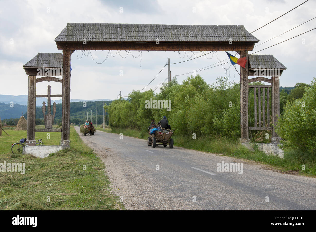 Deux wagons tirés par des chevaux traversent une route dans les Maramures région Banque D'Images