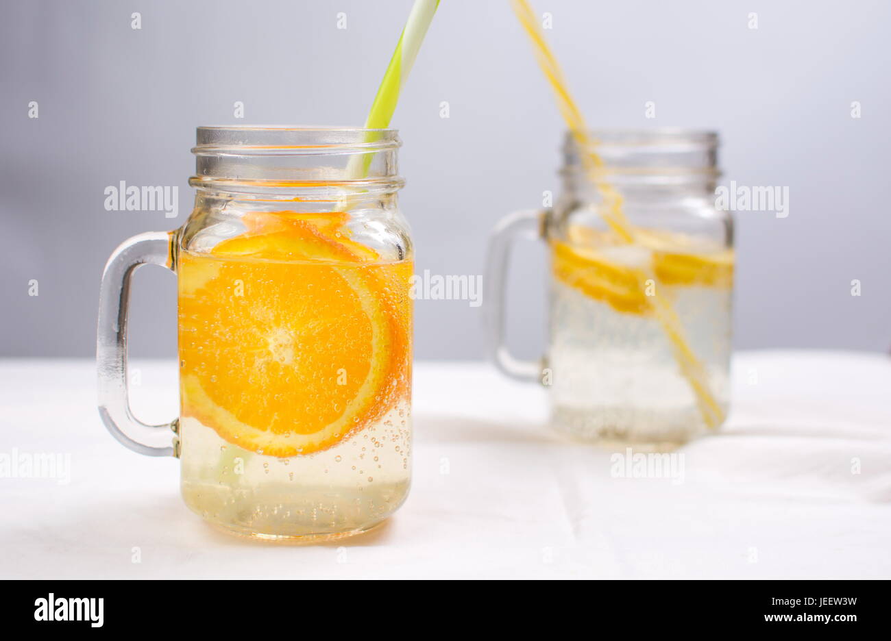 L'eau avec l'orange et le citron dans un bocal en verre. Boisson d'été froide Banque D'Images
