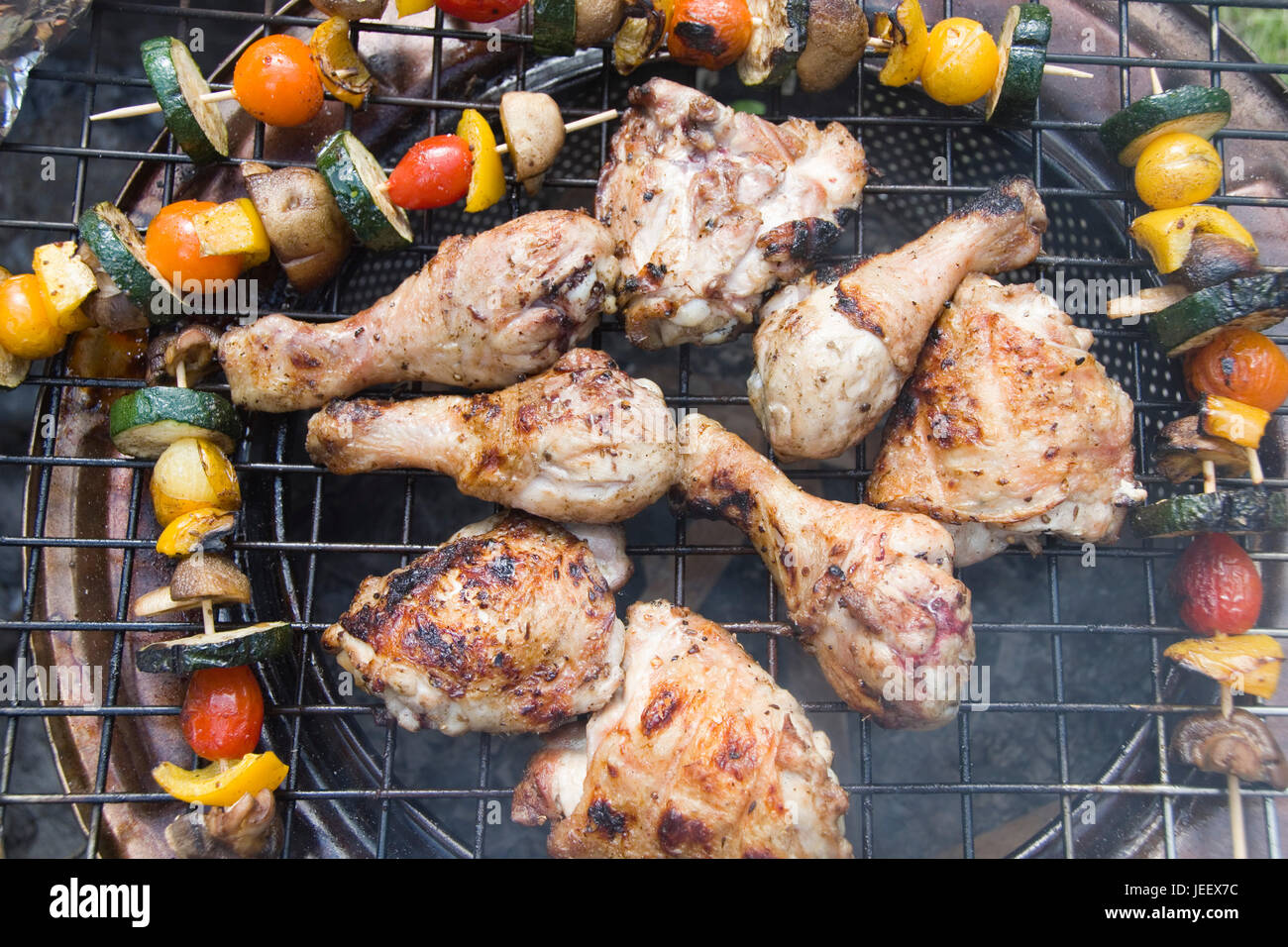 Poulet barbecue Brochettes de légumes colorés et de tomates, courgettes, poivrons et champignons la cuisson en plein air, barbecue d'été, UK Banque D'Images