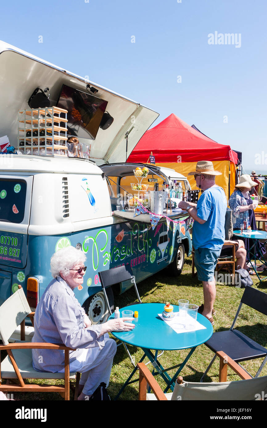 VW camper van transformé en bar mobile. Jusqu'articulée de toit avec femme homme client au petit bar comptoir. Un soleil brillant. Banque D'Images