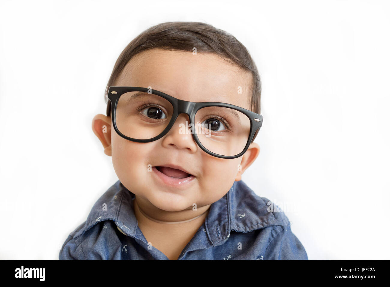 Parution modèle photo d'un mignon, drôle à la baby boy wearing eyeglasses and smiling at the camera against a white background Banque D'Images