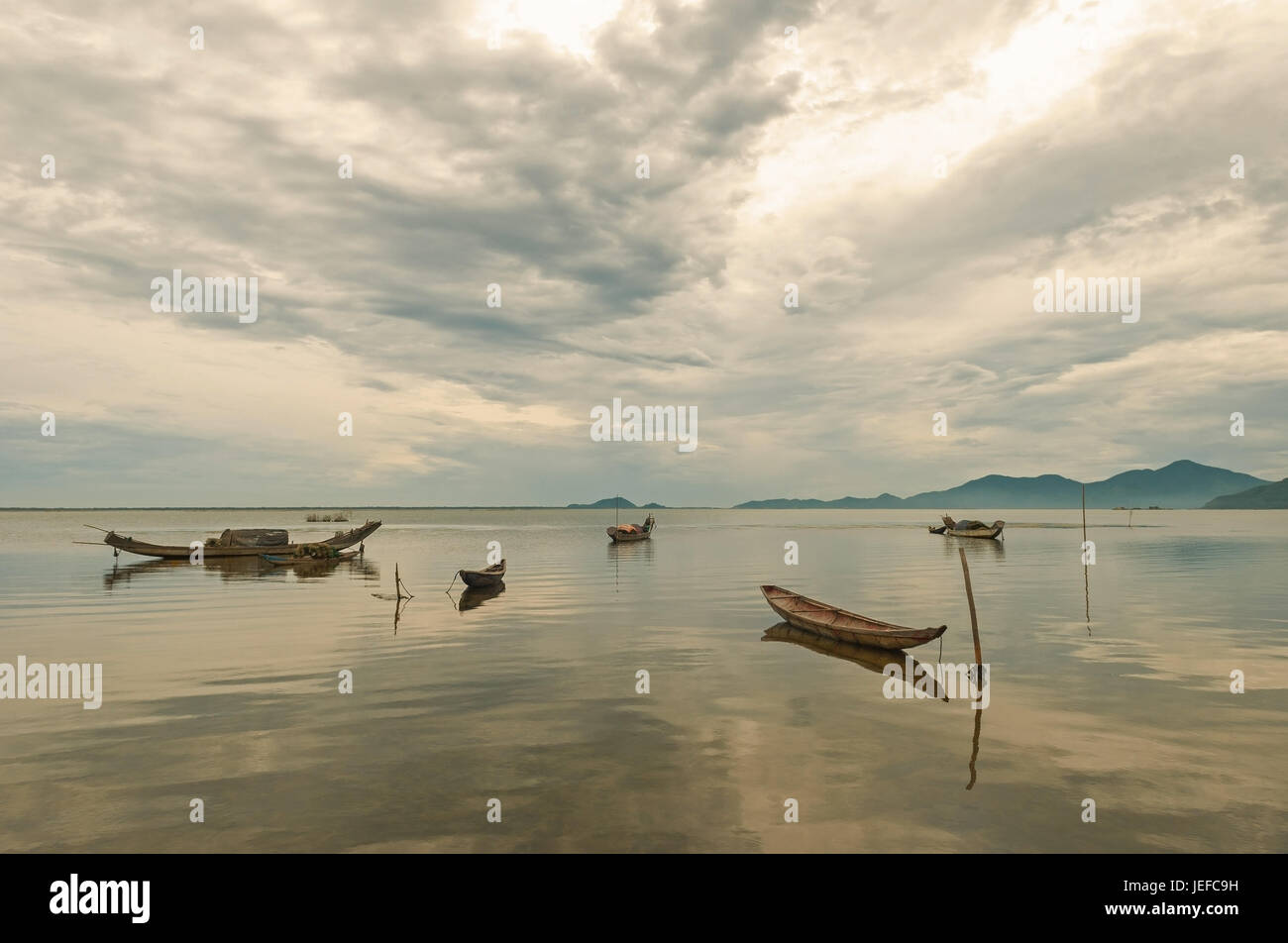Des bateaux de pêche vietnamiens traditionnels Sampan appelée (trois planches) sur un lac dans le centre du pays entre les villes de Hoi An et Hué au lever du soleil, de l'Asie. Banque D'Images