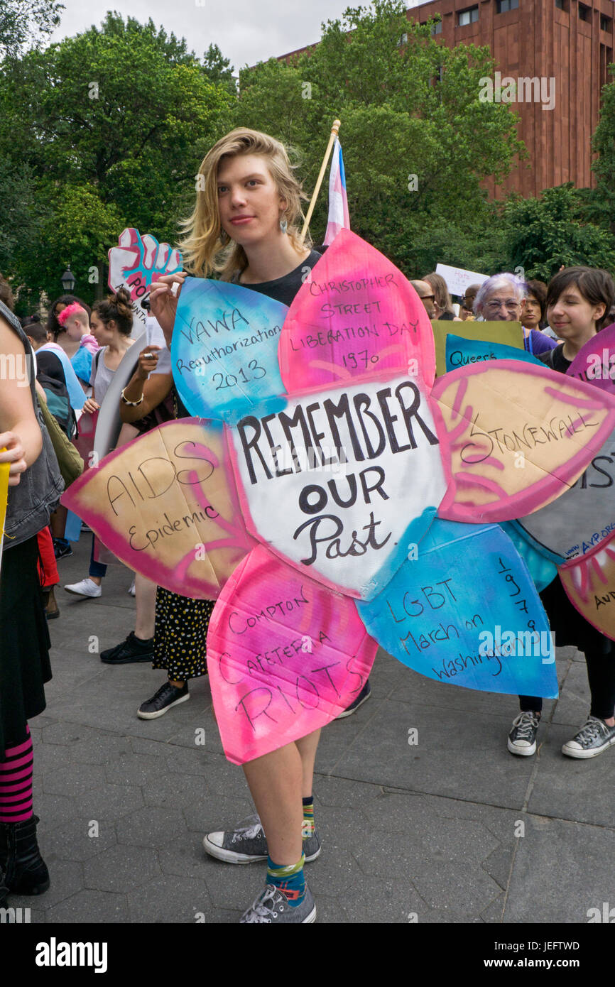 Un marcheur sur la journée d'action Trans rally tenant un signe en forme de fleur avec des noms d'événements importants et les dates dans l'histoire des transgenres. Banque D'Images