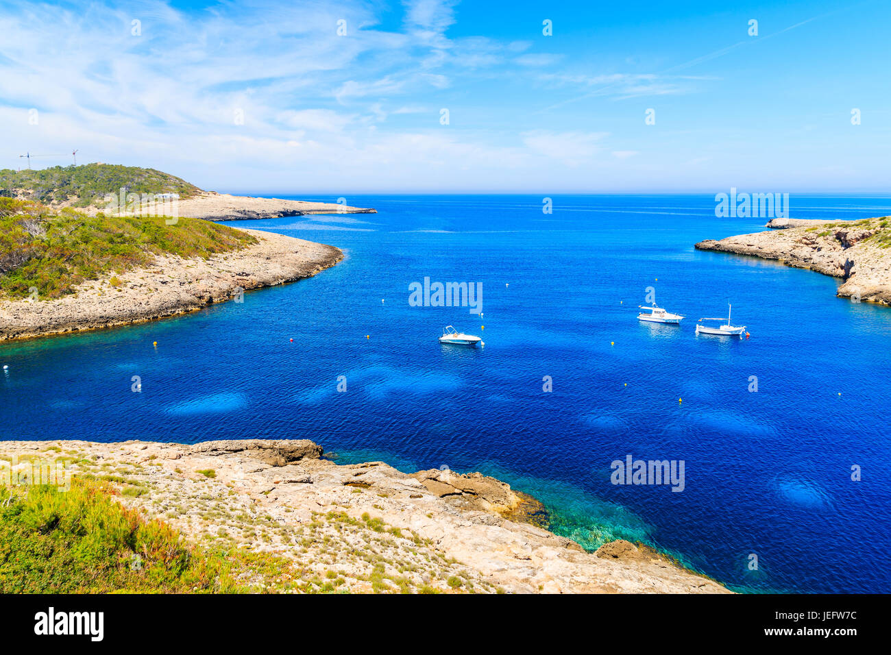 Moteur et bateaux de pêche sur la mer bleue de la baie de Cala Portinatx, Ibiza island, Espagne Banque D'Images