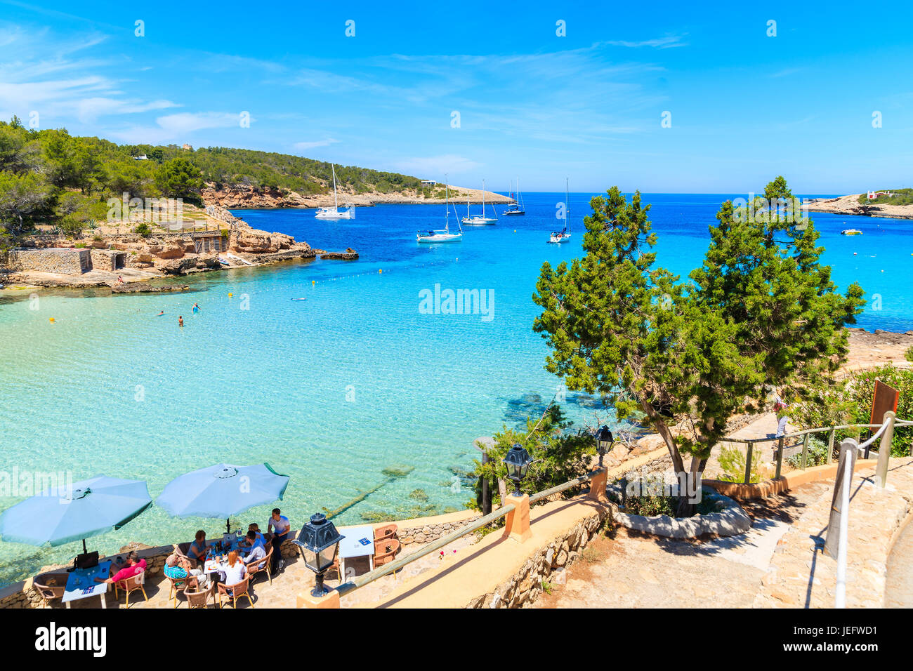 La baie de Cala PORTINATX, IBIZA ISLAND - 16 MAI 2017 : des gens assis dans le restaurant de rive de la baie de Cala Portinatx, Ibiza island, Espagne. Banque D'Images