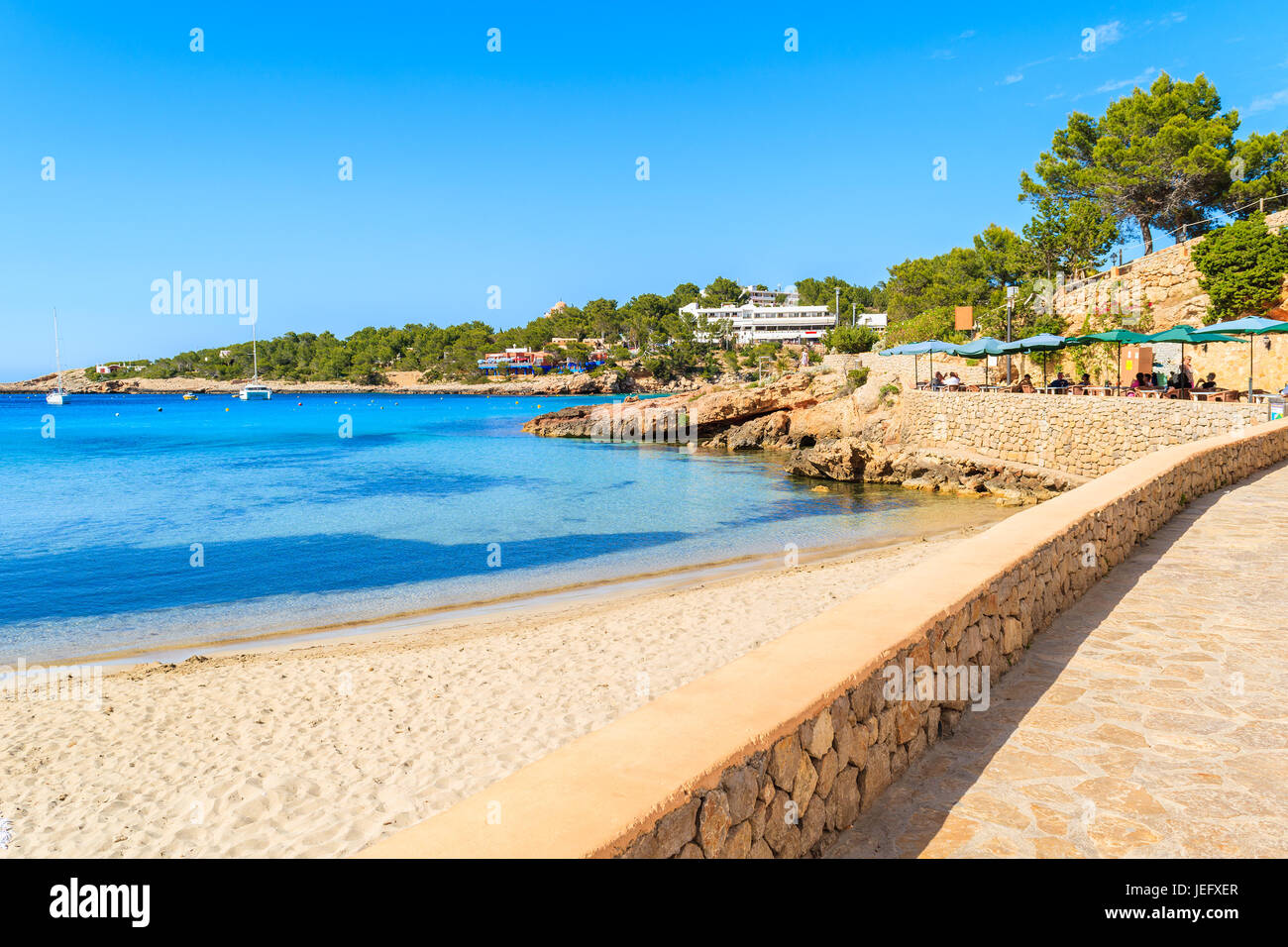 Promenade côtière le long de la plage de Cala Portinatx avec de l'eau de mer bleu azur, l'île d'Ibiza, Espagne Banque D'Images