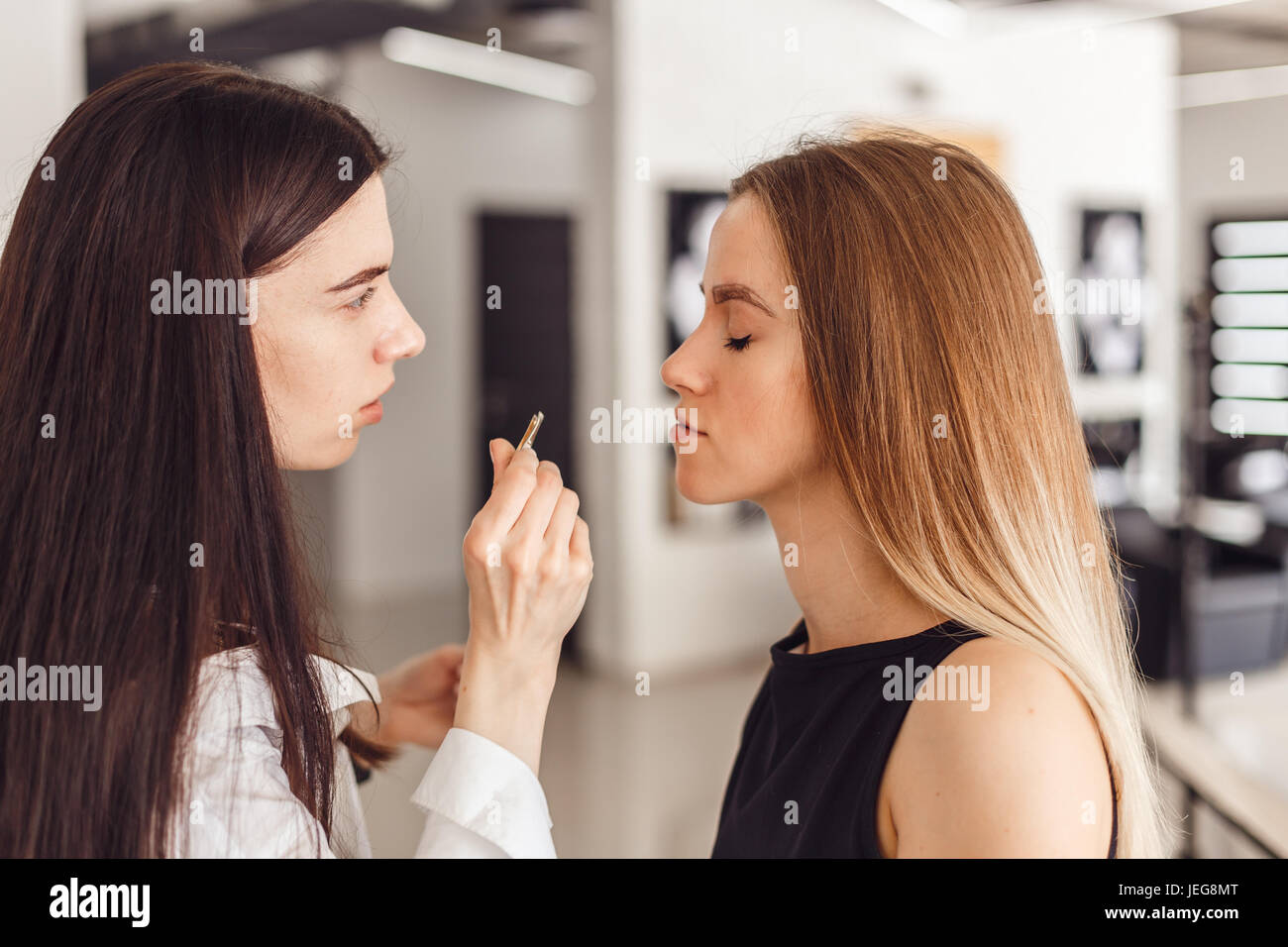 Jeune femme cosmetologistt weezing sourcils de modèle dans salon de beauté Banque D'Images