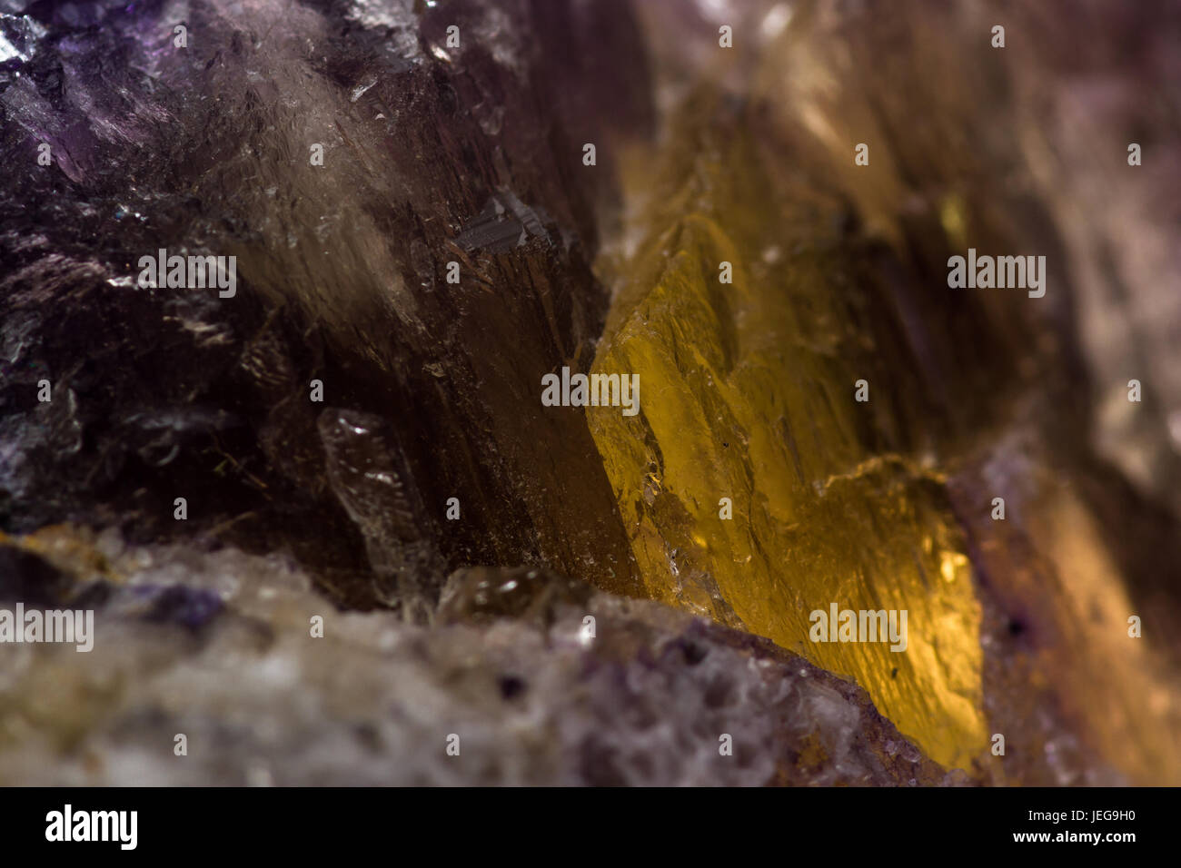 Gros plan d'une fluorite violet pierre avec un patch d'une croissance de cristaux d'or avec elle Banque D'Images
