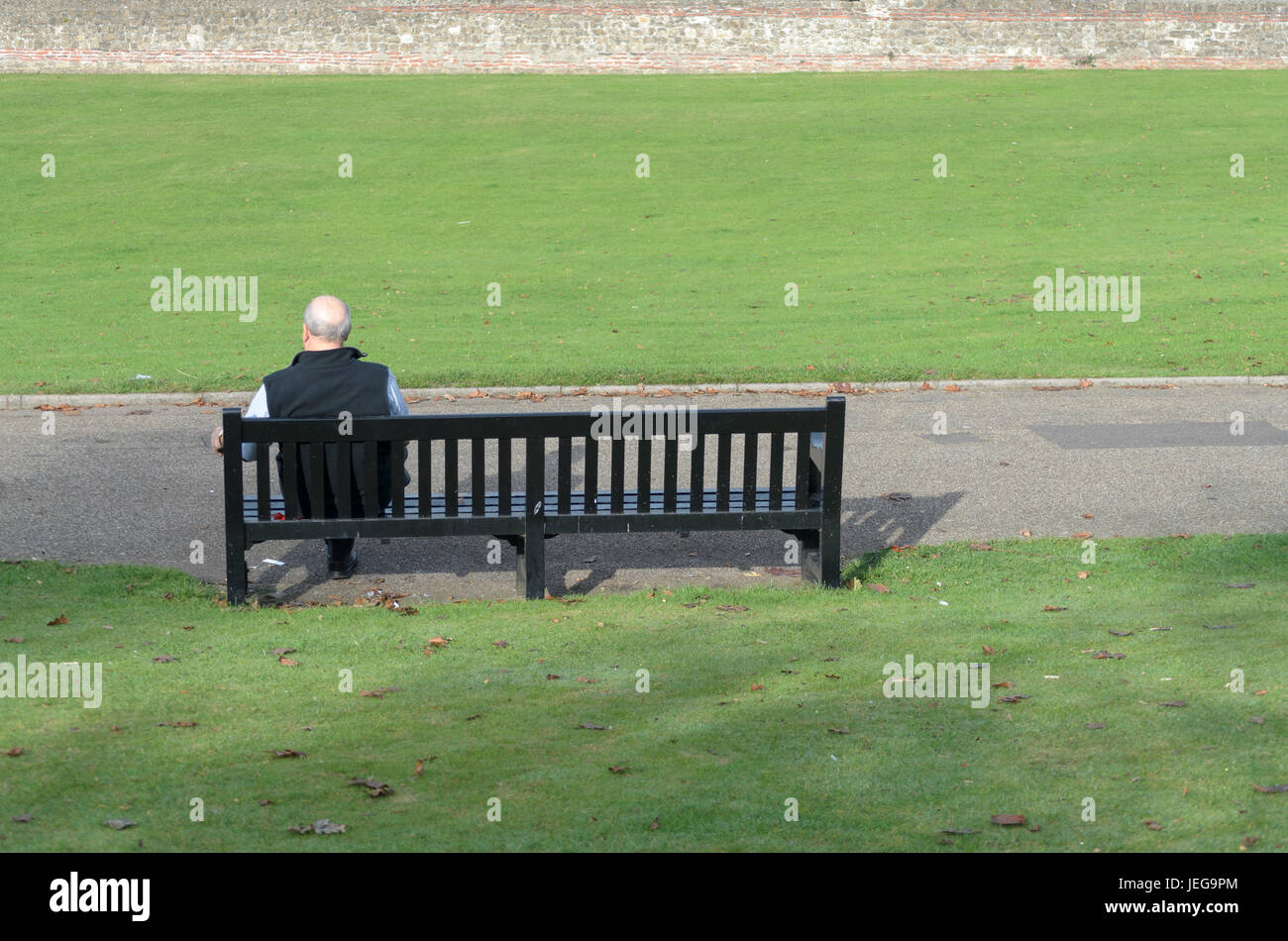 Un homme âgé assis sur un banc dans pensée profonde UK. Banque D'Images