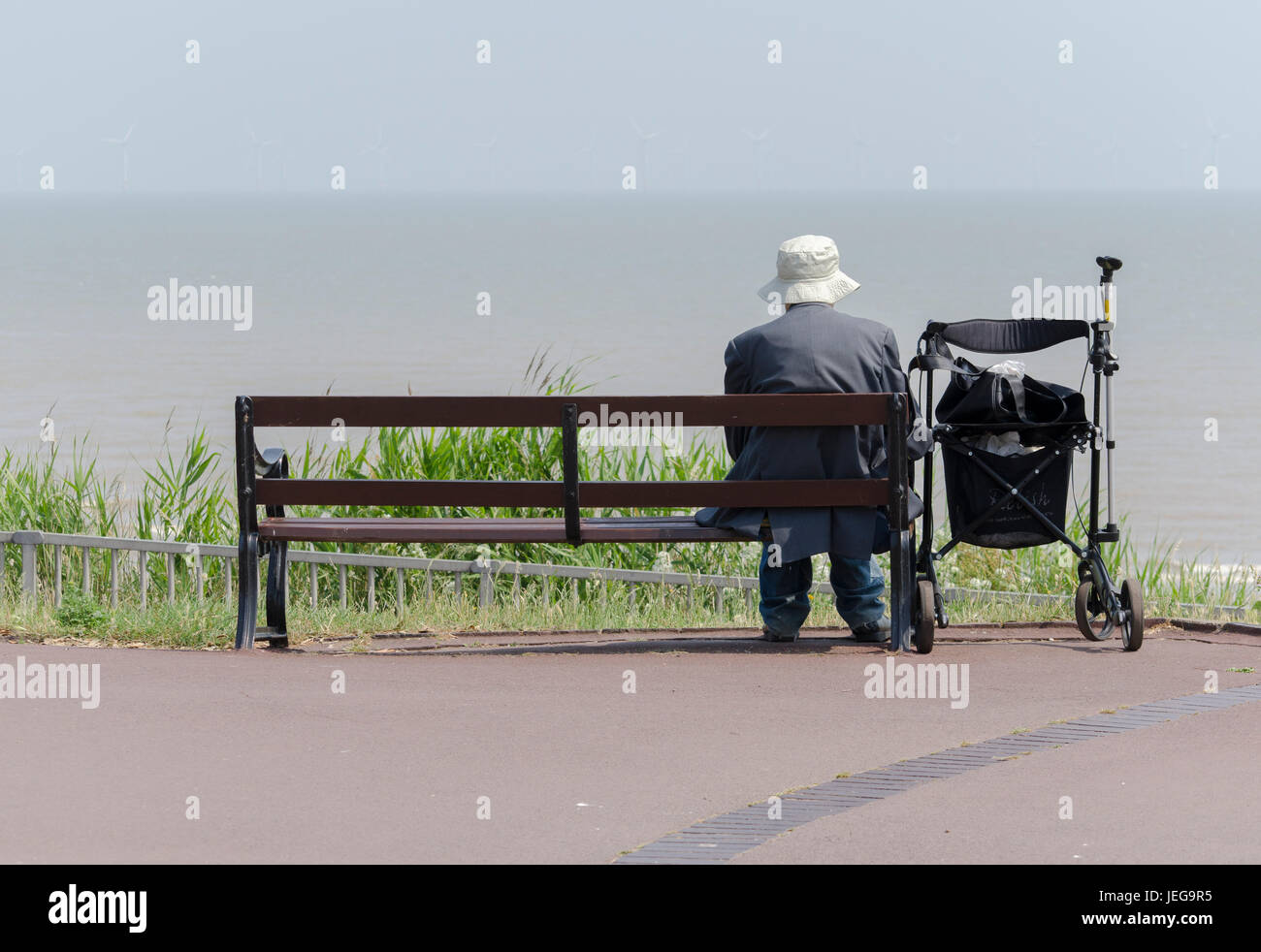 Un homme âgé assis sur un banc dans pensée profonde UK. Banque D'Images