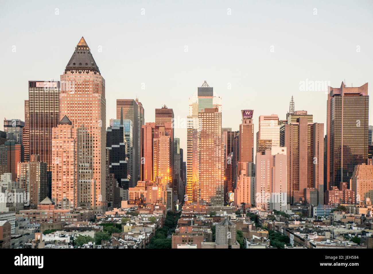 Milieu de l'horizon de Manhattan illuminée par un coucher de soleil avec des réflexions fulgurantes dans windows alignés avec le soleil vu de orb 48 Encre Press Lounge bar sur le toit de l'hôtel Banque D'Images