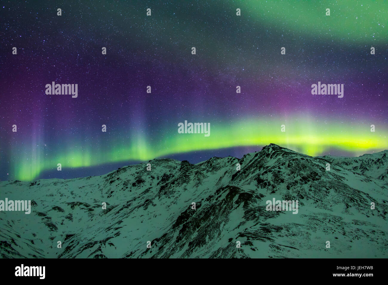 Aurore boréale au-dessus des montagnes dans le Parc National Denali sur un hiver très froid la nuit. La galaxie d'Andromède est visible à gauche Banque D'Images