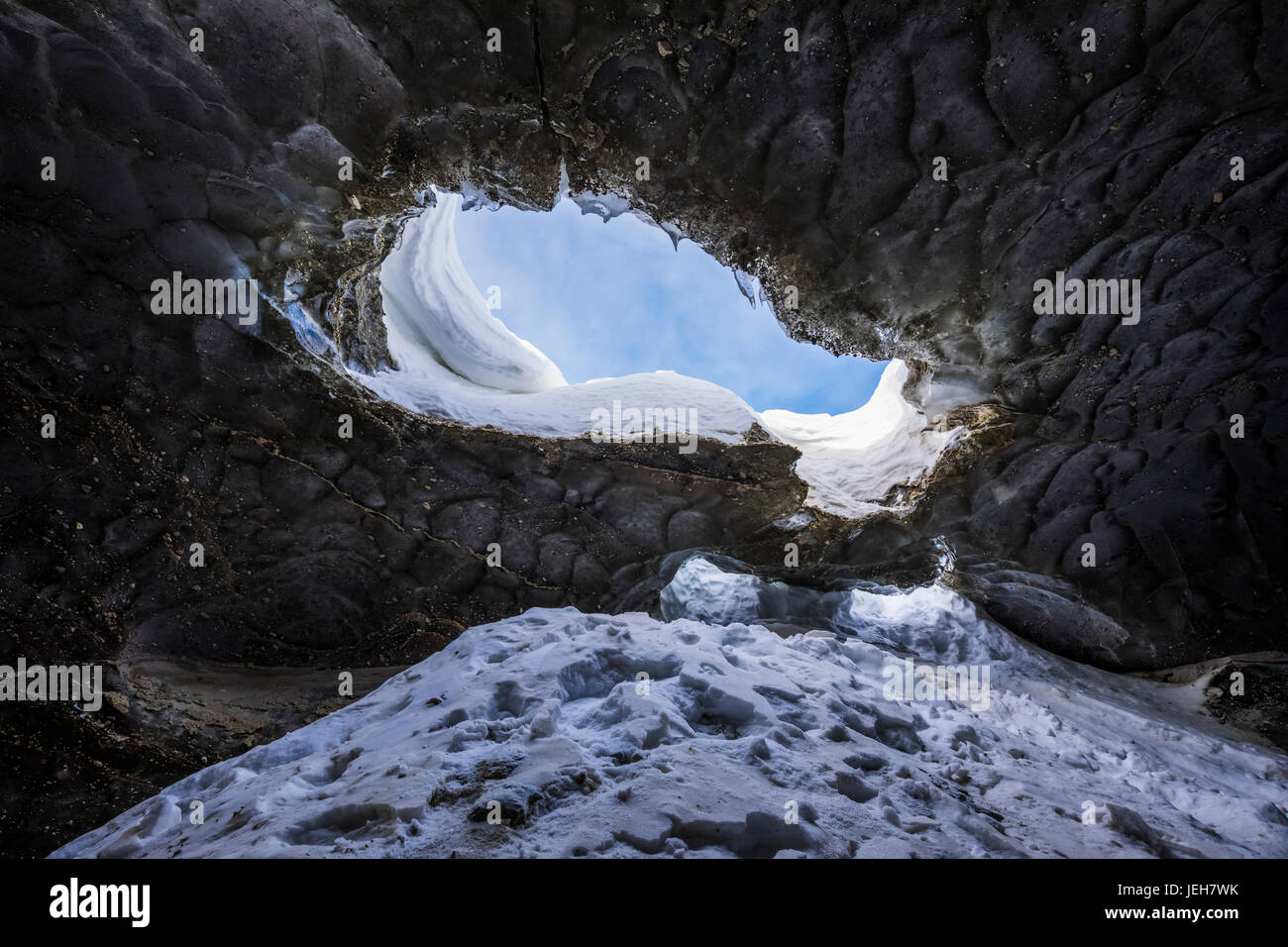 Le ciel est visible à travers un trou dans le plafond de cette grotte de glace du glacier Castner dans la chaîne de l'Alaska ; Alaska, États-Unis d'Amérique Banque D'Images