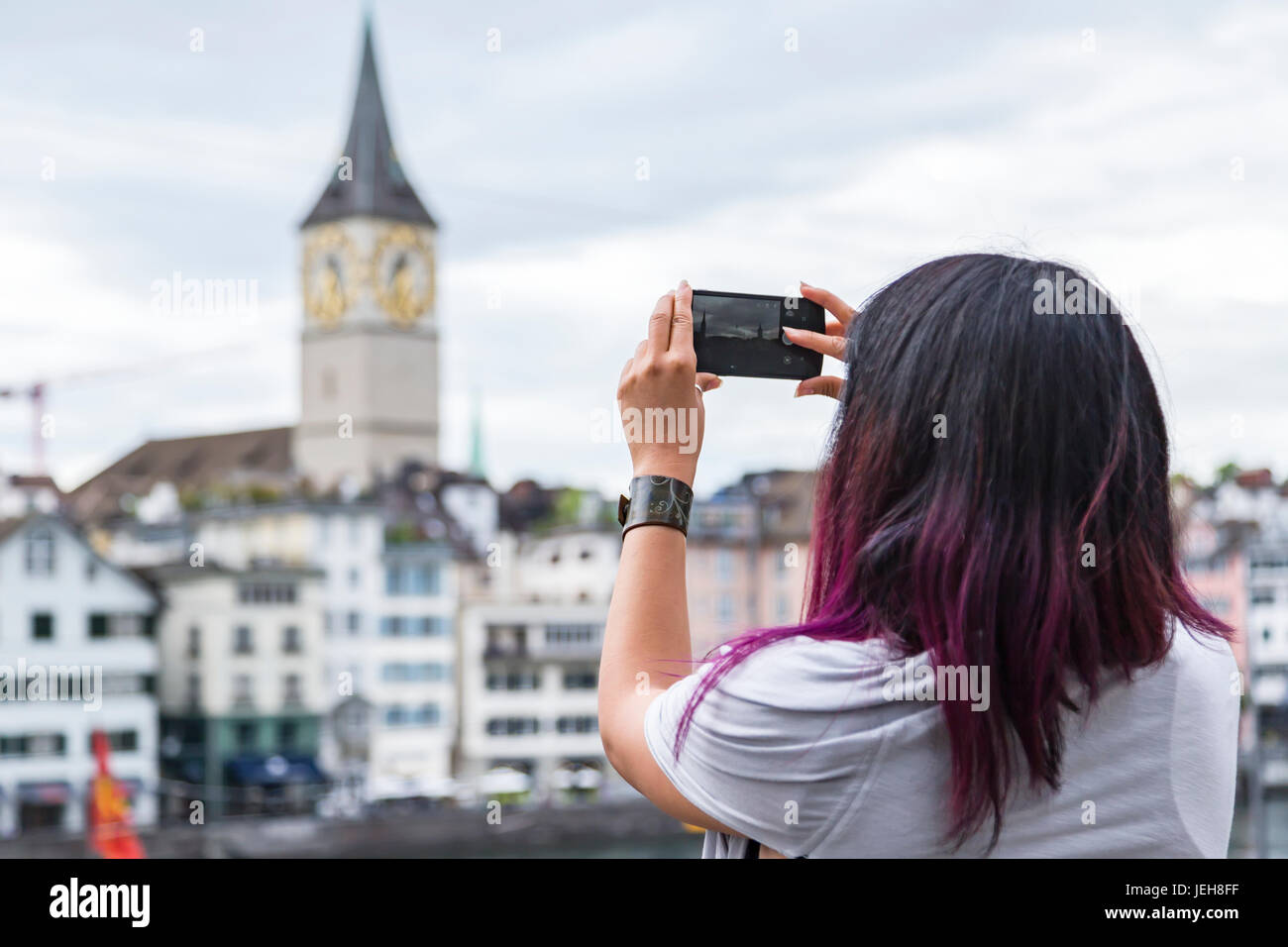 Une femme prend une photo de paysage touristique avec son téléphone pendant les vacances ; Zurich, Suisse Banque D'Images