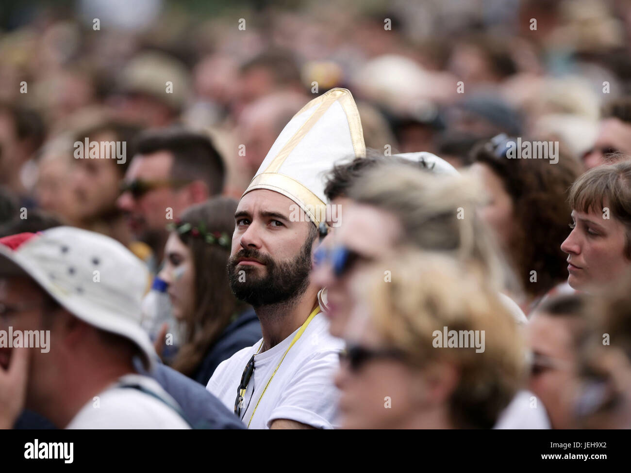 Un festivaliers dans le port d'un chapeau de style tiare papale regardant Laura Marling produisent sur la scène de la pyramide à Glastonbury Festival, à Digne Farm dans le Somerset. Banque D'Images