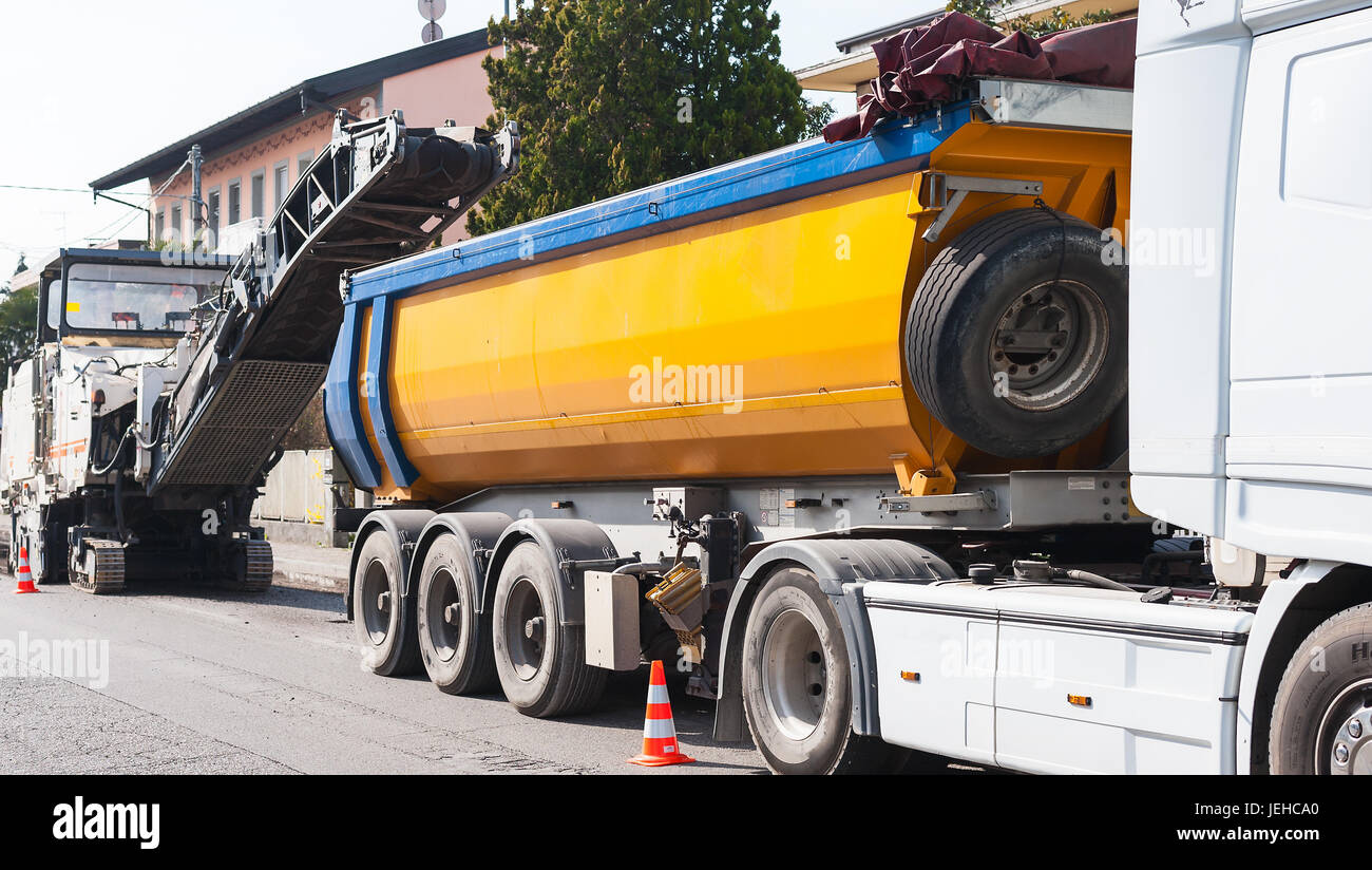 La construction de routes, l'asphalte d'une route. Camion Dumper est chargé avec de l'asphalte de machine fraiseuse à froid. Banque D'Images