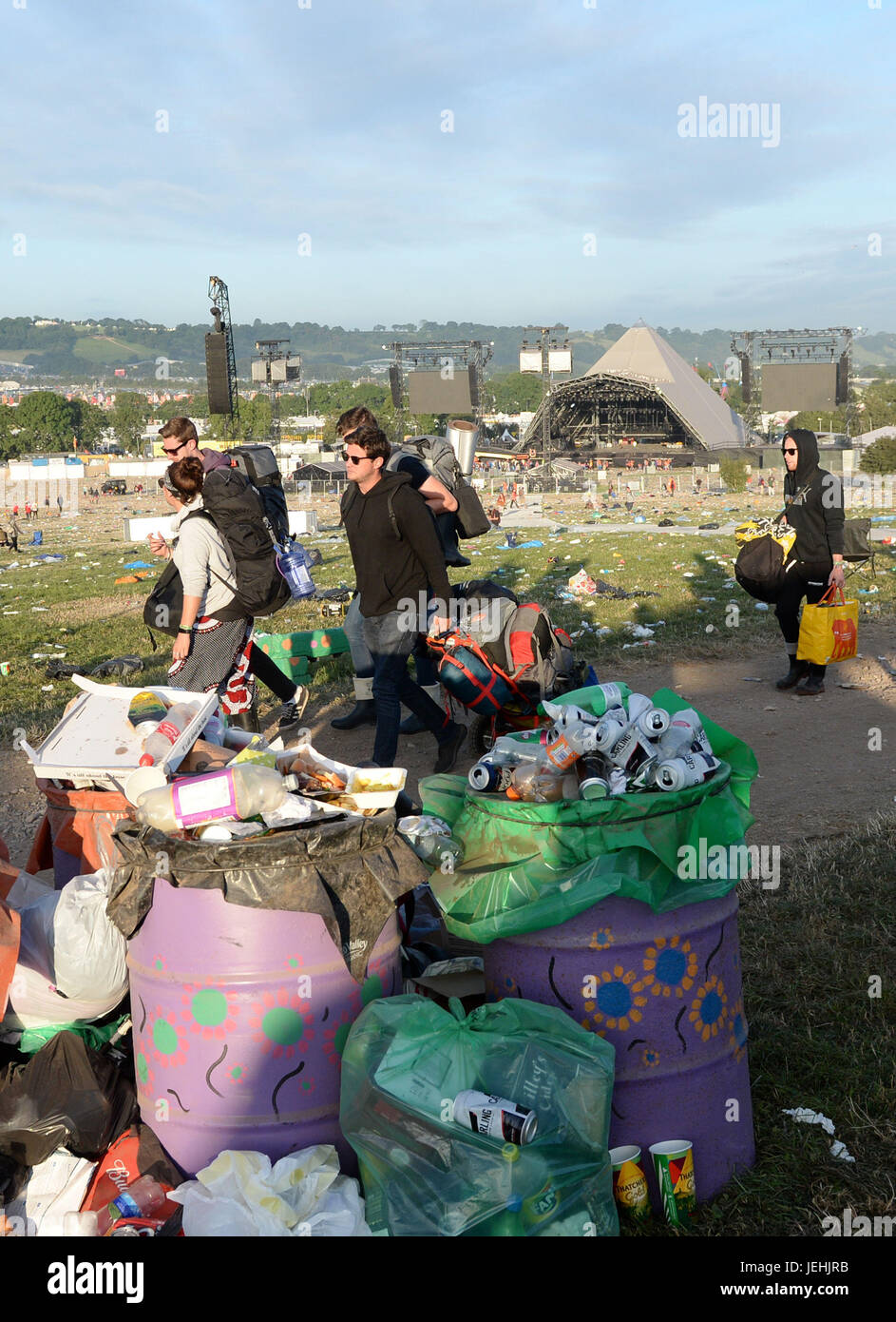 Les festivaliers à pied passé détritus qu'ils quittent après au festival de Glastonbury à la ferme digne dans Pilton, Somerset. Banque D'Images