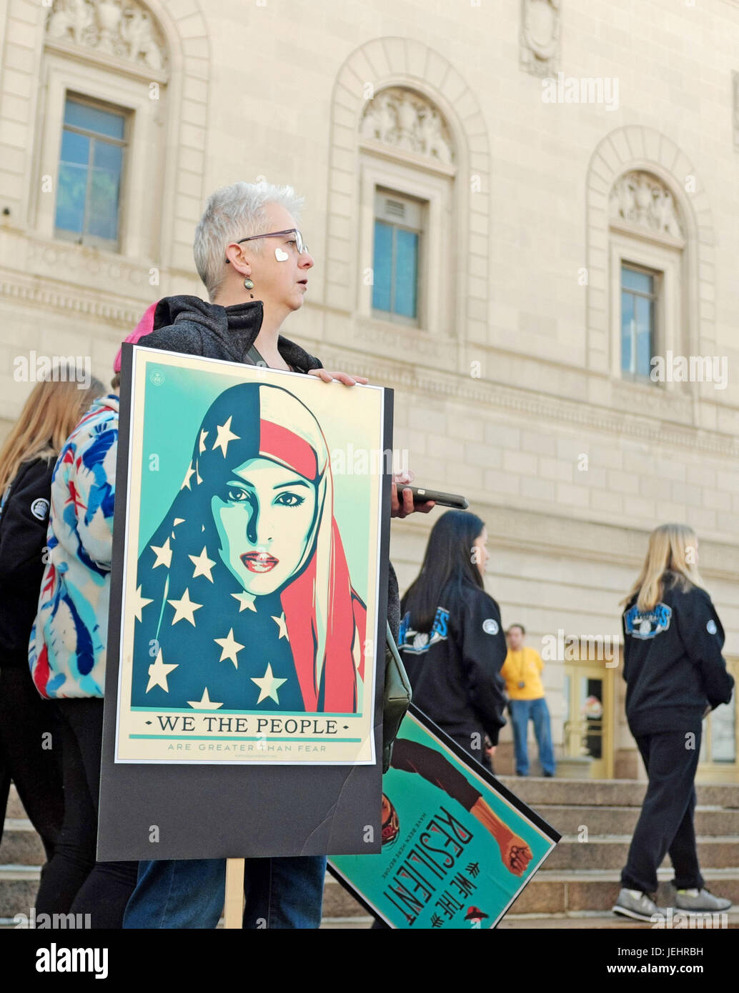 Les manifestants, une femme dans la région de Cleveland, Ohio est titulaire d'une photo par Shepard Fairey symbolisant la résistance civique à l'action du gouvernement des États-Unis. Banque D'Images