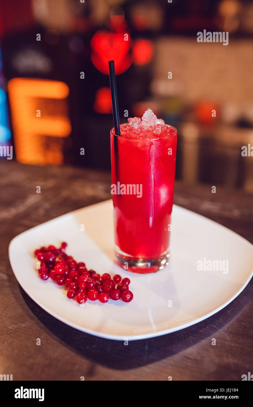 Dans un verre de jus de canneberges sur une assiette blanche décorée de Cranberry. Banque D'Images