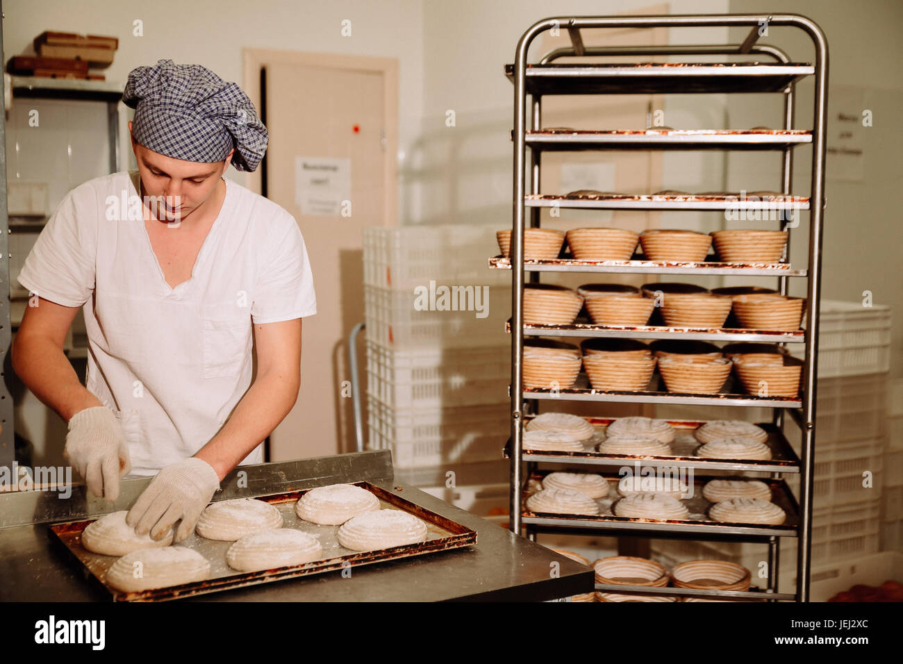 Un boulanger fait des incisions manuel sur la pâte pour le pain. La fabrication de pain.Bakery Banque D'Images