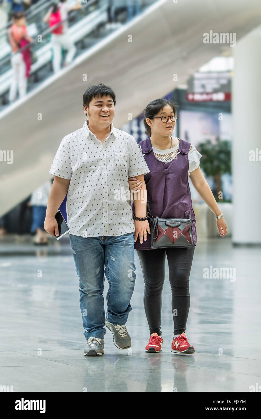 PÉKIN-15 MAI 2016. Couple en surpoids dans le centre commercial. La taille moyenne des mâles urbains chinois est passée de 63.5 cm en 1985 à 76.2 cm. Banque D'Images
