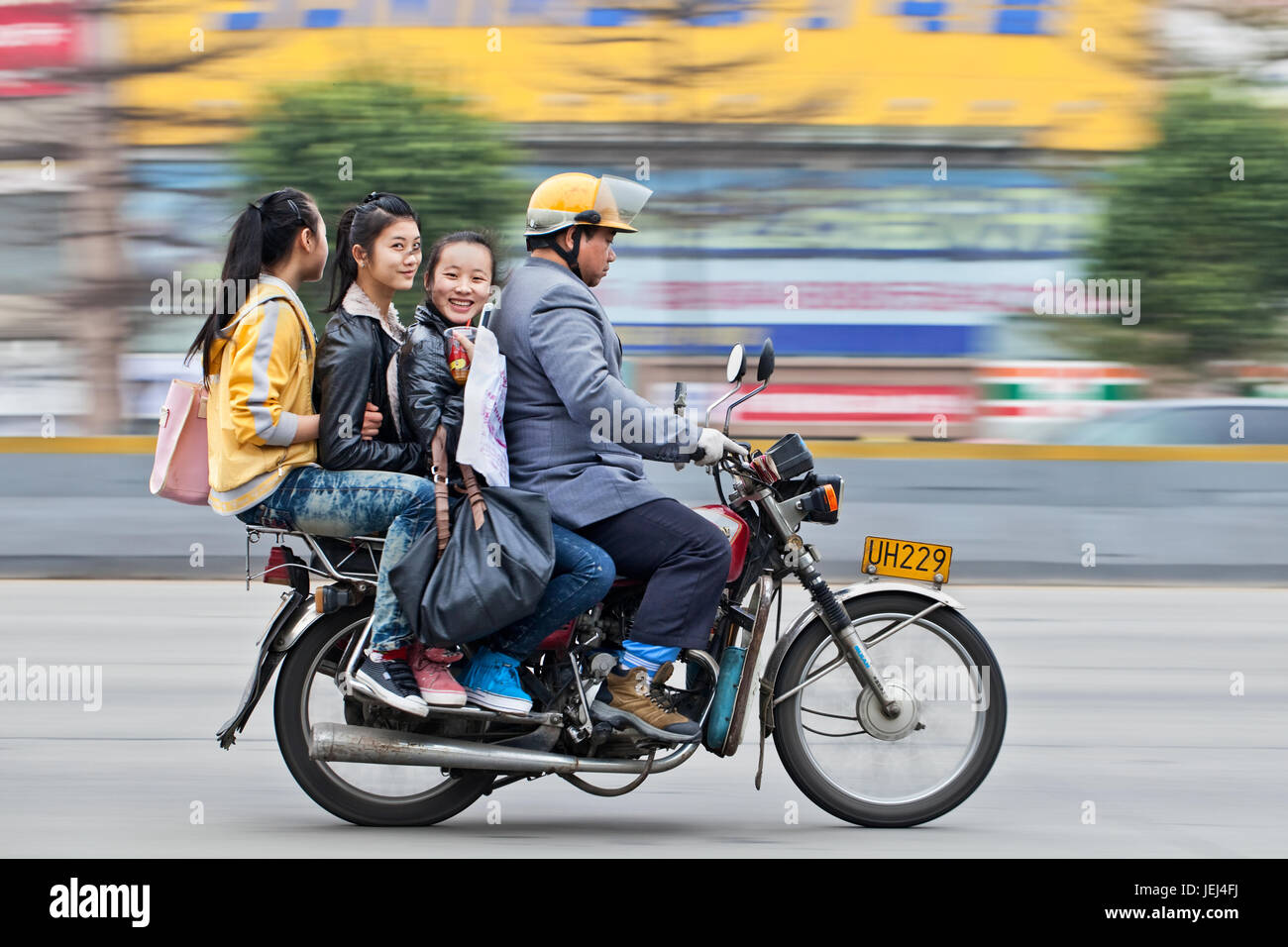 GUANGZHOU-FÉVRIER. 22, 2012. Taxi moto avec trois jeunes filles gaies sur la route avec mouvement flou arrière-plan. Banque D'Images