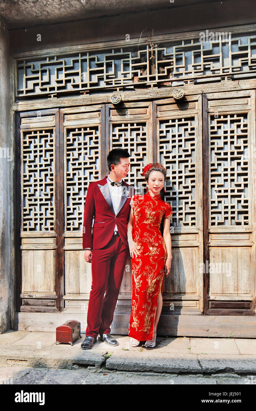 HENGDIAN-CHINE-14 AVRIL 2014. Les modèles chinois posent pour la photographie de mariage contre l'ancienne construction en bois. Les mariages sont de grandes entreprises en Chine. Banque D'Images