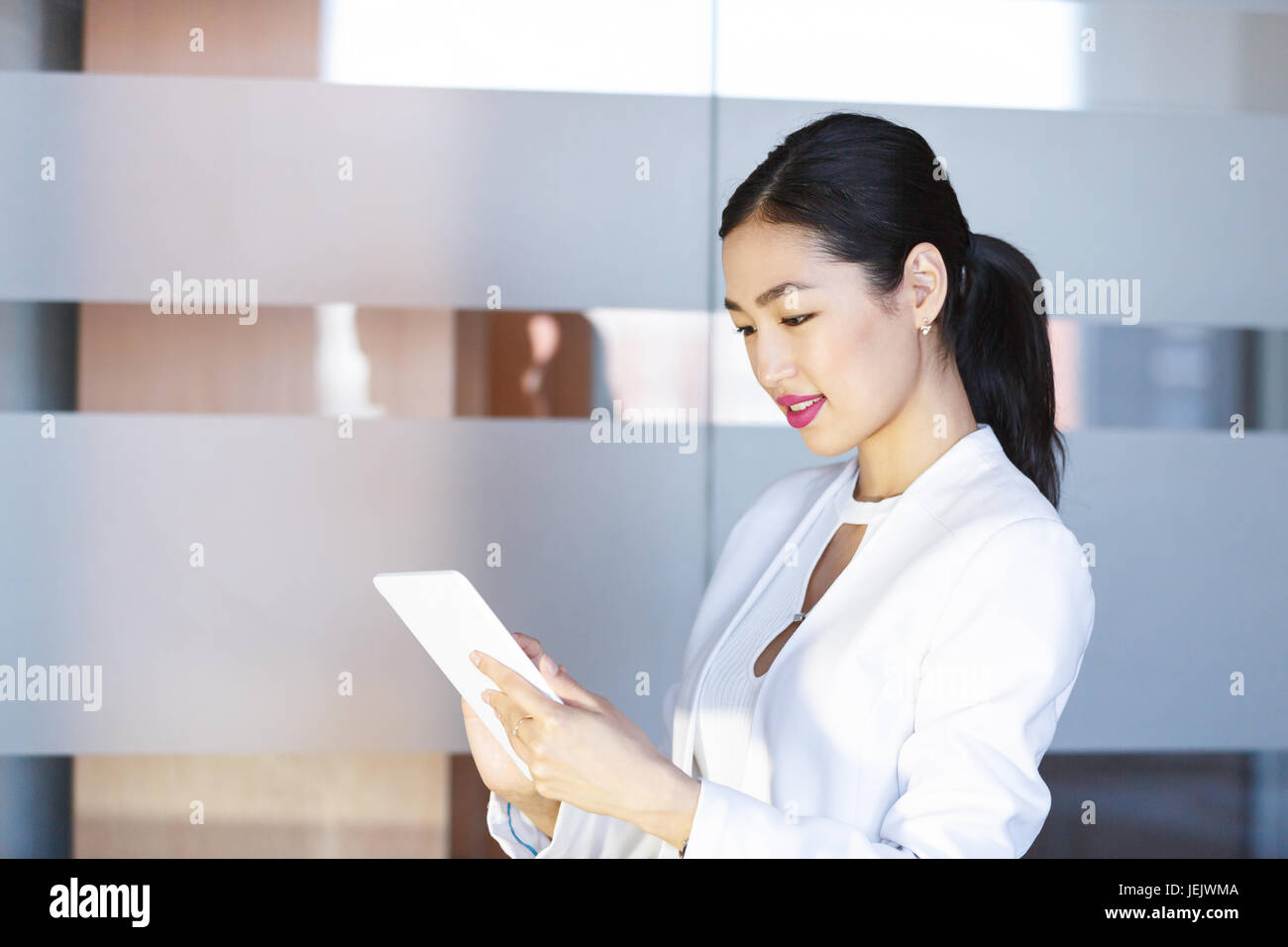Asian young woman with tablet at office Banque D'Images