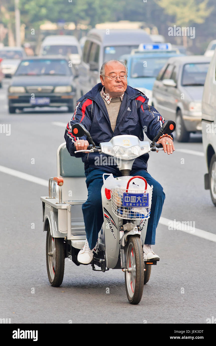 Personnes âgées chinois sur e-bike. Vélos motorisés dans les villes chinoises sont devenus rares, le nombre de bicyclettes électriques en Chine a dépassé 200 millions de dollars. Banque D'Images