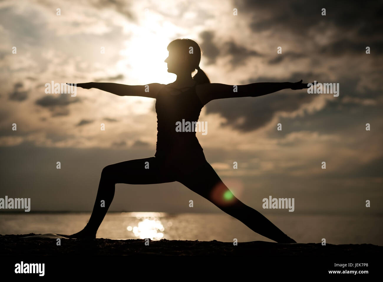 Mettre en place sportive woman faisant l'asana Virabhadrasana 2 guerrier pose posture dans la nature. Banque D'Images
