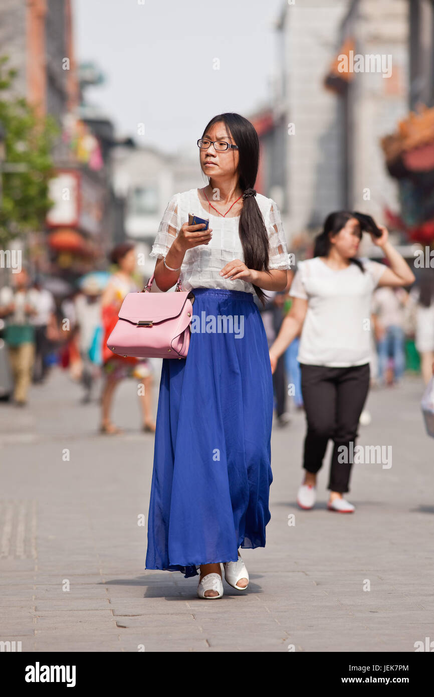 PÉKIN-9 JUIN 2015. Une jeune femme habillée à la mode marche dans le  centre-ville. Plus de 27 femmes et non mariées en Chine sont désignées  comme des femmes de gauche Photo Stock -