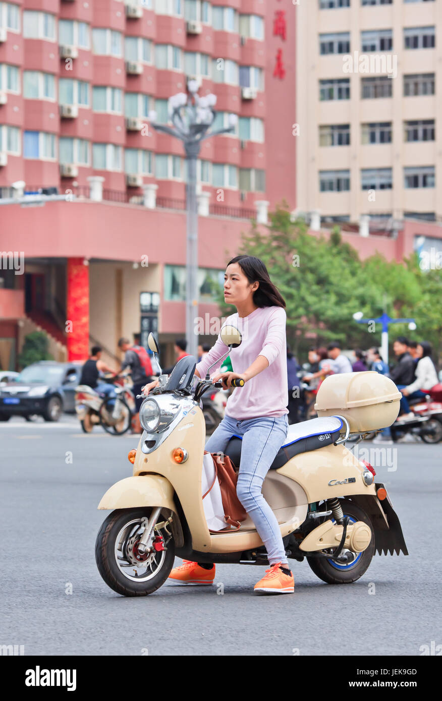 KUNMING-30 JUIN 2014. Fille sur un e-vélo. On estime que 200 millions de Chinois utilisent maintenant des vélos électroniques, soit une augmentation de 1 000 par rapport à il y a 15 ans. Banque D'Images